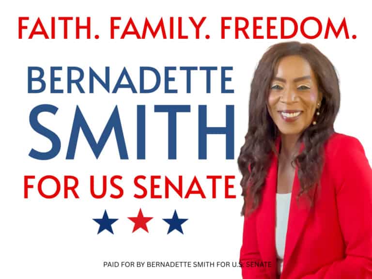Bernadette Smith campaigning for U.S. Senate, smiling woman in red blazer.