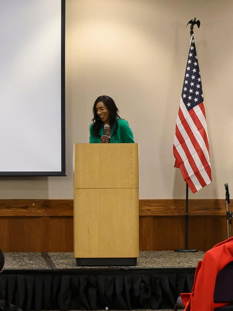 Bernadette Smith speaking at a podium during a campaign event.